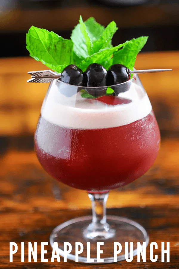 Cocktail with foam in snifter, cherries and mint