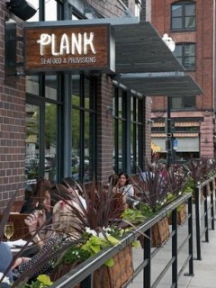 Outside patio with people sitting at tables at Plank Seafood in Omaha