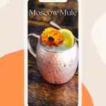 Cocktail in a copper mug with an orange slice and orange flower