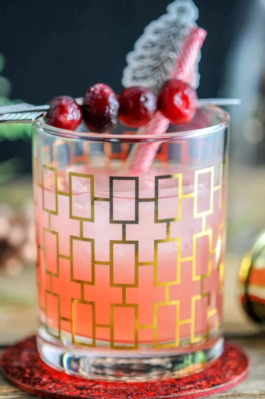 Red Hound Cranberry Vodka Cocktail in gold etched glass, gold jigger