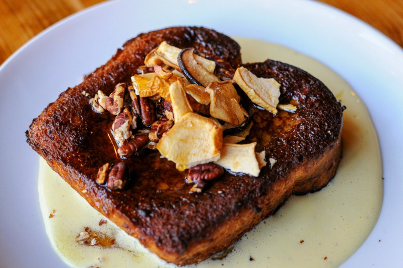 French Toast with dried apples and sauce beneath on white plate