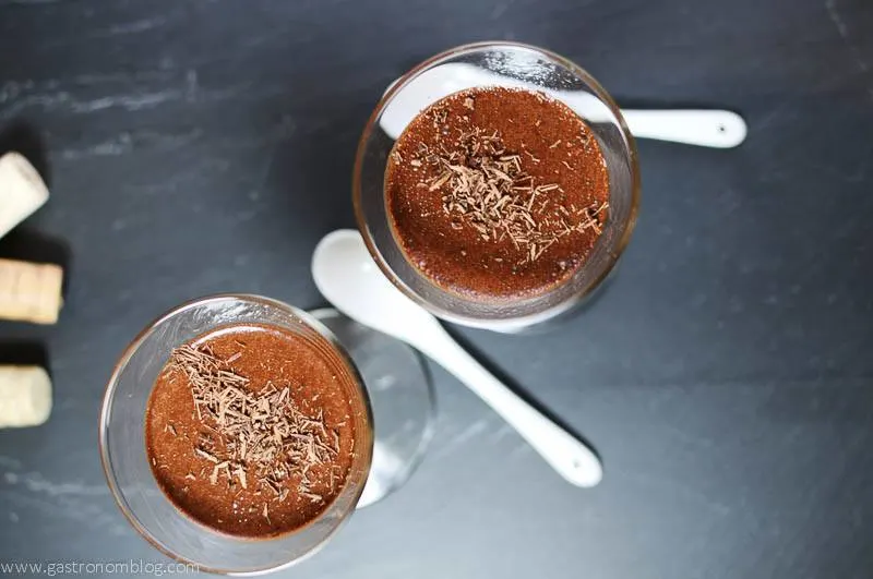 Chocolate Pot de Creme for dessert. Can be made adult with rum or bourbon or even port added in. Perfect decadent chocolate dessert to share with your sweetheart from Gastronomblog! #chocolatechips #chocolate #gastronomblog #whiskey #dessert Chocolate Pot de Creme in glasses, white spoons on a slate board