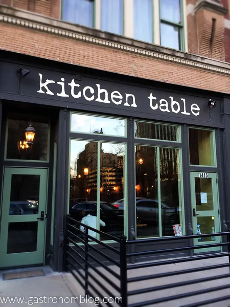 Outside picture of Kitchen Table Omaha, a local farm to table restaurant. Black walls, green trim