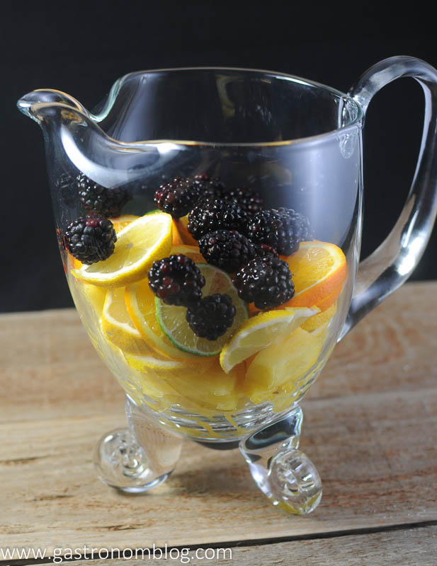 Clear pitcher with limes, lemons, oranges and blackberries