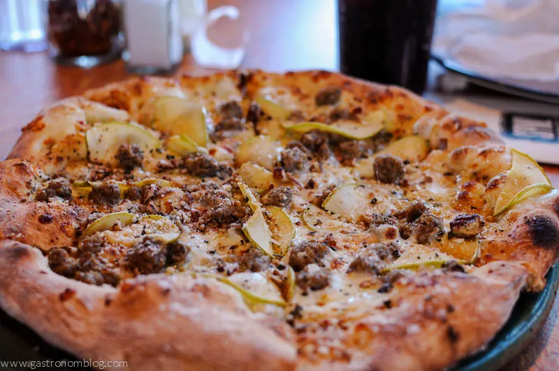 Pizza with pear slices, sausage and cheese on top