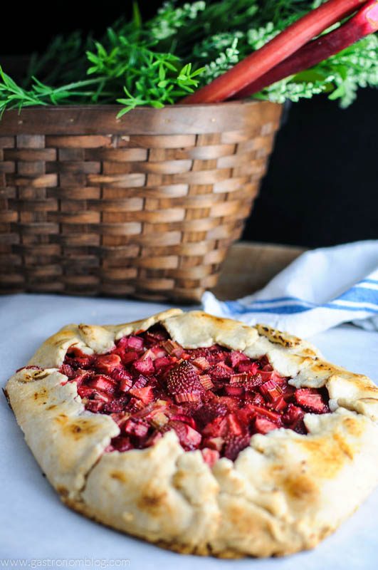 Strawberry Rhubarb Tart on parchment paper with a napkin and basket in background