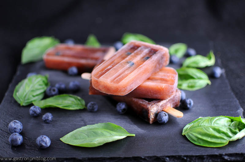 Red Chianti Icepops with blueberries and basil leaves on a slate