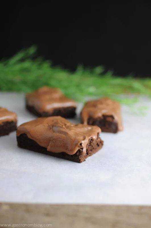Root Beer Whiskey Brownies on parchment with greenery in background