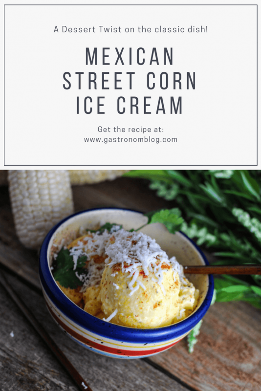 Mexican Street Corn Ice Cream - yellow ice cream topped with shredded cheese in striped colorful bowl with wooden spoon. Ears of corn and flowers on wood table. 