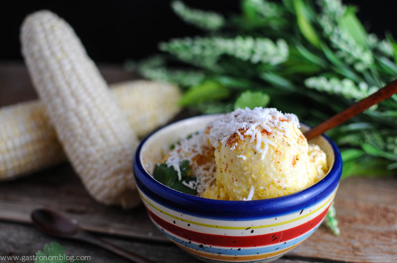 Corn Ice Cream in striped bowl with corn ears and flowers in the background