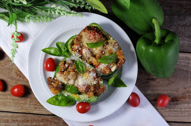 Stuffed Cheesy Italian Peppers on a white plate with cherries and on a white napkin