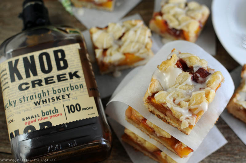 Bourbon Peach Shortbread Bars - top shot, stack of bars and whiskey bottle on left side