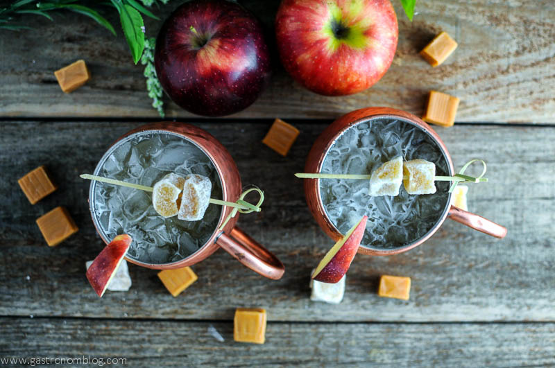 Copper Moscow Mule Mugs with caramel apple mule, crystallized ginger on cocktail picks, caramel squares and apples