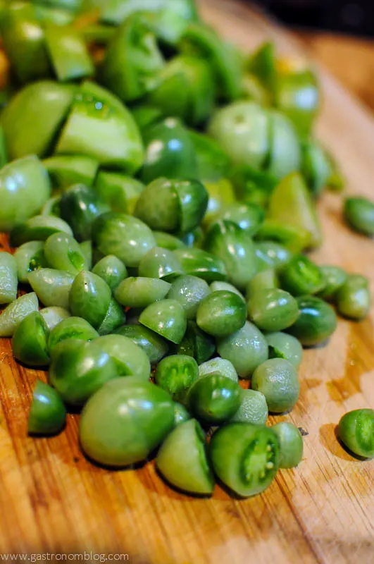 Green Tomato Jam - pile of green tomatoes on cutting board. 
