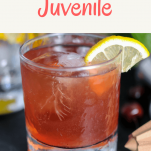 Superlative Juvenile Cocktail in a glass with a lemon wedge