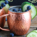 Blueberries and Cucumbers in copper mug, cucumber slices, blueberries around