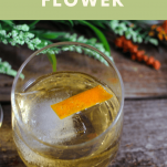 Normandy Flower Cocktail in a wine glass with an orange peel