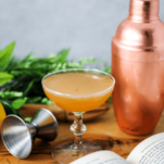 Orange cocktail in coupe with copper shaker