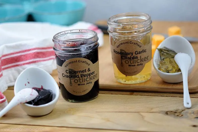 Cabernet and Chablis jams in jars with ceramic containers and spoons on a wood surface