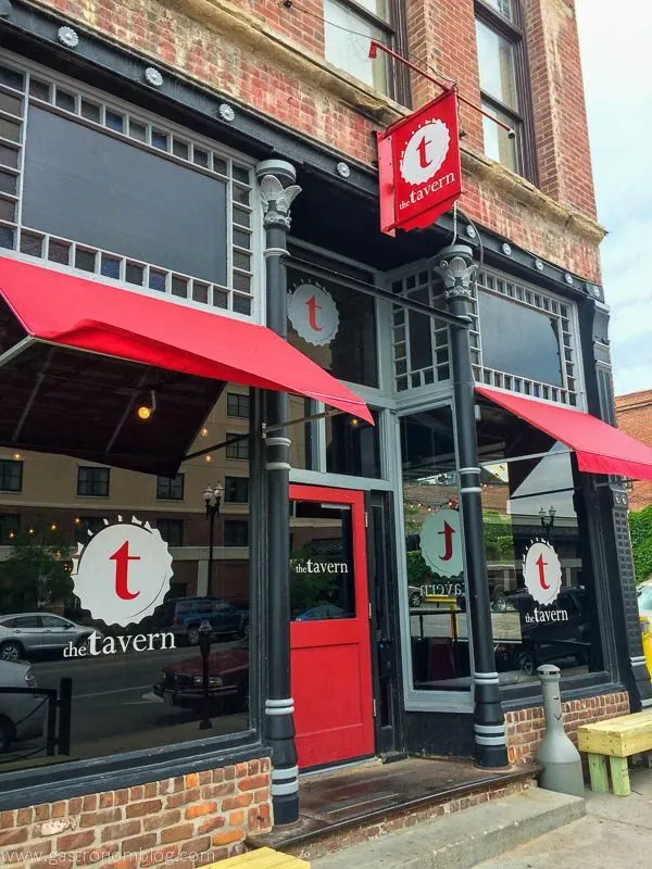 The Tavern, Old Market, Omaha, Nebraska, outside shot of red awnings and door, trim painted black brick building