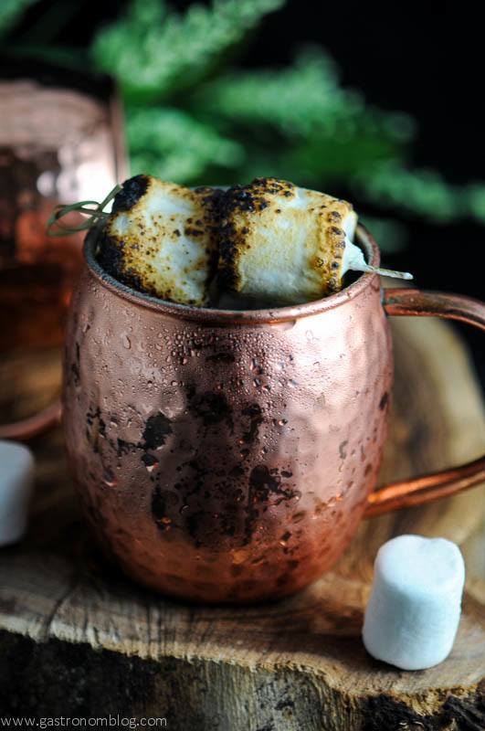 The Campfire Mule - copper mug with burnt marshmallow on top, marshmallow on wood board