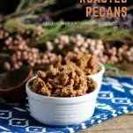 Bourbon Roasted Pecans in white bowls on blue and white napkins. Flowers behind