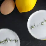 Top shot of foam cocktails, thyme leaves on top, egg and lemon