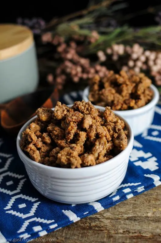 Bourbon Candied Pecans in white bowls on blue and white napkin