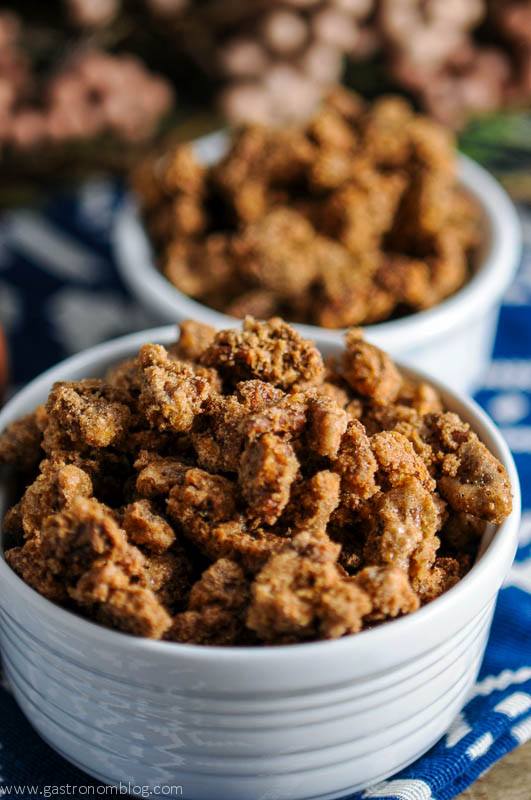 Bourbon Candied Pecans in white bowls on blue and white napkin