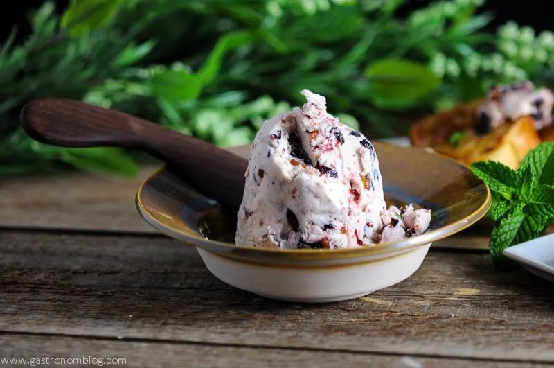 French Toast with Blueberry Thyme Butter - perfect for breakfast or brunch, this savory French Toast version is so tasty! Topped with maple syrup from Gastronomblog! #recipe #breakfast #blueberry #bread #gastronomblog pink Blueberry Thyme Butter in a butter server, wooden spoon, and flowers in background