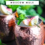 Peach Basil Moscow Mule in copper mug with peaches, candied ginger and basil sprig