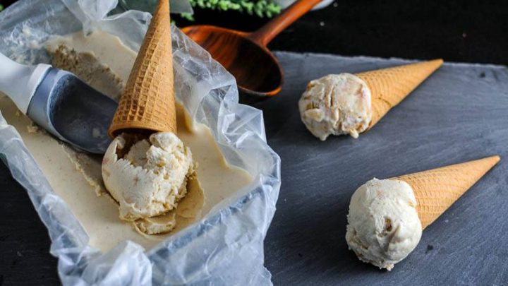 Bourbon and Peach No Churn Ice Cream in cones and bread pan lined with parchment, ice cream scoop on slate