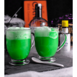 Green cocktails in mugs with halloween decor in backgroun