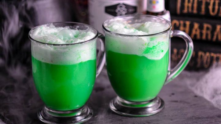 Polyjuice Potion, green cocktails in glass mugs, halloween decor behind