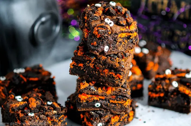 brownies with orange layer and googly eyes with Halloween themed backdrop