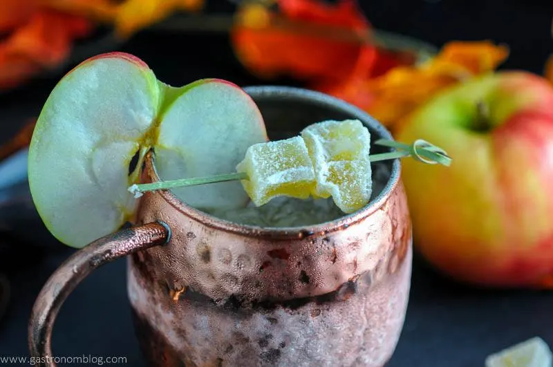 The Maple and Cider Kentucky Mule in copper mug with apple slice and candied ginger