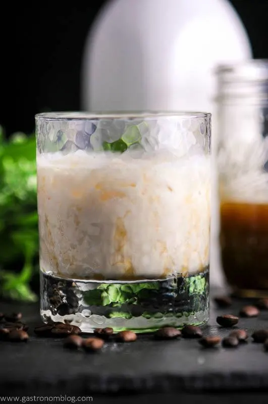 Salted Bourbon Butterscotch White Russian Cocktail in a rocks glass, white bottle behind