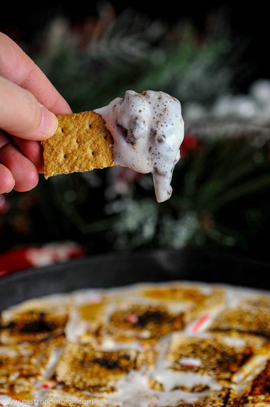 Candy Cane Skillet Smores with Boozy Marshmallows, showing graham cracker with dop on it. 