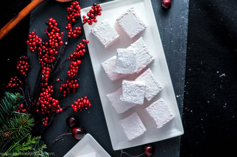 Cherry Amaretto Boozy Marshmallows on white plate. red berries branch