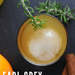 Top shot of orange cocktail in rocks glass with rosemary sprig