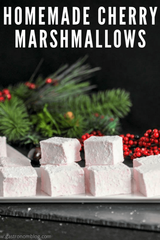 Pink marshmallows on white plate with greenery behind