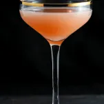 Pink cocktail in gold rimmed coupe