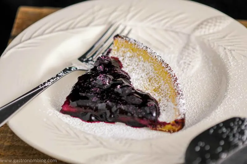 Dutch Baby Pancake with Blueberry Whiskey Sauce on white plate with fork