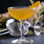 Gold cocktail in coupe with orange peel