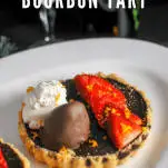 Chocolate tarts on white plate with strawberries and whipped cream