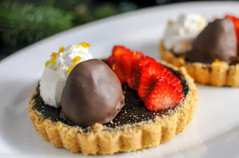 Chocolate Bourbon Tart with Strawberries on a white plate