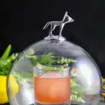 Pink cocktail in rocks glass with glass domb over the top