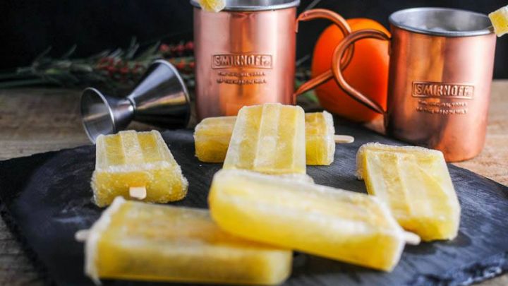 Sunrise Over Moscow Mule Ice Pops on slate, copper mugs and orange behind
