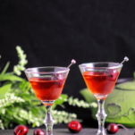 Red cocktails in small glasses with cherries