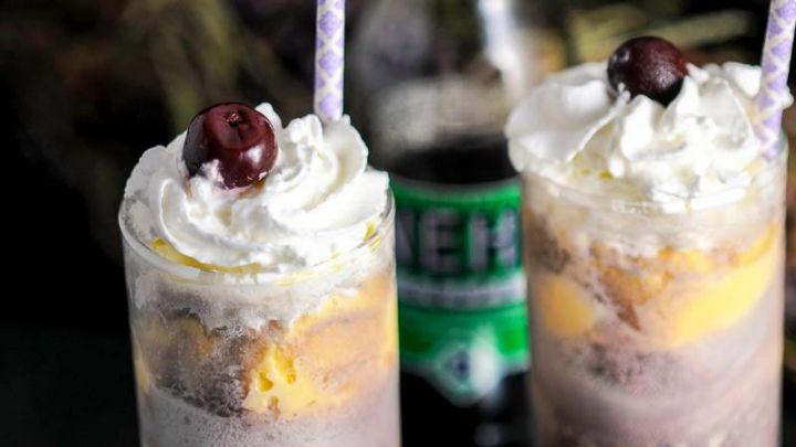 Adult Purple Cow Float with Nehi Grape Soda in glasses with whipped cream and cherries. Grape soda bottle behind